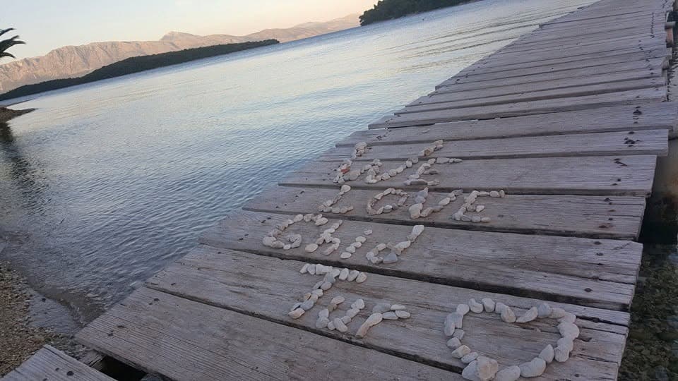 “We love GhidTur” spelled in shells on a wooden pier.